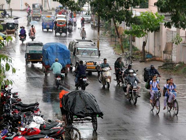 People move during rain in Berhampur near Gopalpur sea beach as cyclone Hudhud looms. (PTI photo)