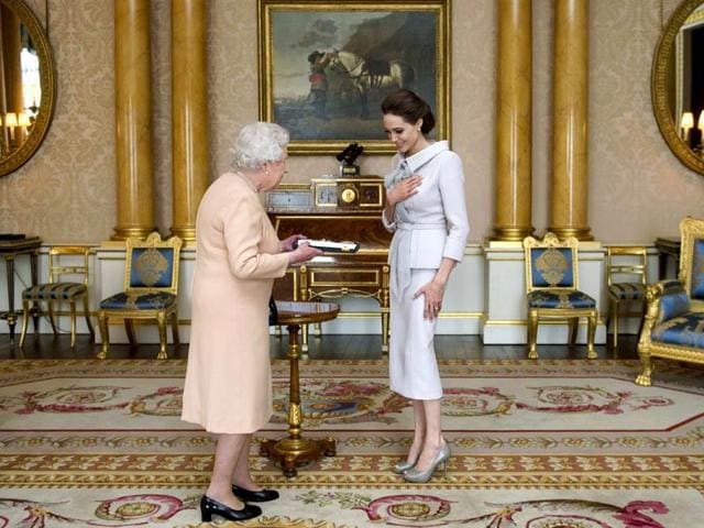 Actor-Angelina-Jolie-is-presented-with-the-Insignia-of-an-Honorary-Dame-Grand-Cross-of-the-Most-Distinguished-Order-of-St-Michael-and-St-George-by-Britain-s-Queen-Elizabeth-in-the-1844-room-at-Buckingham-Palace-in-London-October-10-2014-Reuters