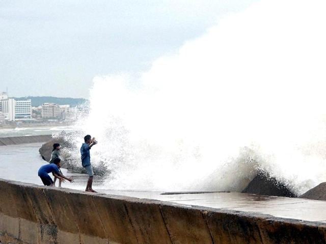 People look at a sea tide at Vizag on Sunday. (PTI Photo)