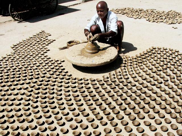 A potter makes earthen lamps (diyas) ahead of Diwali in Ajmer. (PTI Photo)