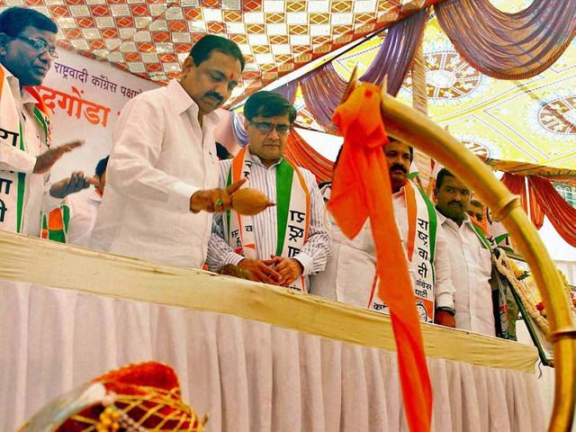 Former Maharashtra rural development minister Jayant Patil breaks a coconut during the launch ceremony of assembly elections campaign rally at Haripur village in Sangli. (PTI Photo)