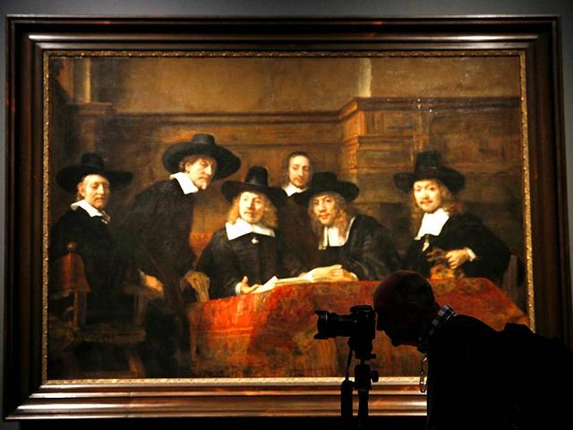 A photographer works in front of a painting entitled The Sampling Officials of the Amsterdam Drapers Guild also known as The Syndics by Dutch artist Rembrandt, during a photocall in the National Gallery in London, on October 14, 2014. The painting is a part of an exhibition entitled Rembrandt: The Late Works, which explores the artist's final years of painting. (AFP) A photographer works in front of a painting entitled The Sampling Officials of the Amsterdam Drapers Guild also known as The Syndics by Dutch artist Rembrandt, during a photocall in the National Gallery in London, on October 14, 2014. The painting is a part of an exhibition entitled Rembrandt: The Late Works, which explores the artist's final years of painting. (AFP)