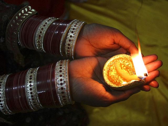 A Hindu Pakistani girl holds a clay lamp during Diwali at a local temple in Lahore, Pakistan, on Thursday. (AP Photo)