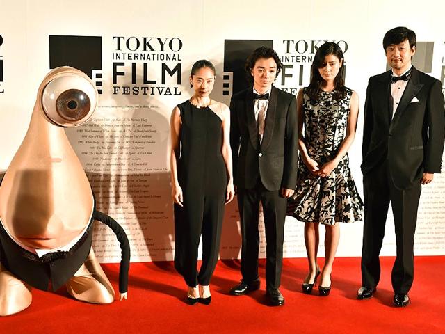 Takashi Yamazaki (R), Japanese director of Parasyte, and actor Ai Hashimoto (2R), actor Shota Sometani (3R), actor Rie Fukatsu (2L) and manga character Migi pose on the red carpet for the 27th Tokyo International Film Festival opening ceremony in Tokyo on October 23, 2014. The Tokyo International Film Festival opens on October 23 with its focus heavily on Japanese animated movies and with cult superhero Ultraman set to swoosh down the red carpet with Prime Minister Shinzo Abe. (AFP) 
