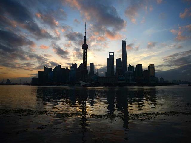 The sun rises behind the skyline of Pudong's Lujiazui Financial District in Shanghai. (AFP Photo)