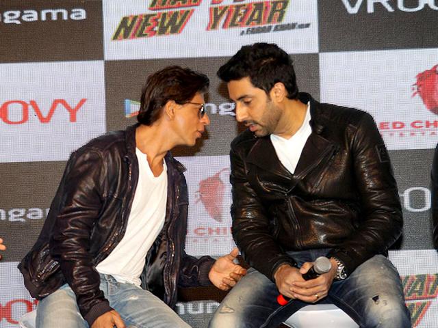 Shah Rukh Khan and Abhishek Bachchan caught in a candid moment sharing a secret at an event to promote the official mobile game of Happy New Year. (Photo: IANS) Shah Rukh Khan and Abhishek Bachchan caught in a candid moment sharing a secret at an event to promote the official mobile game of Happy New Year. (Photo: IANS)