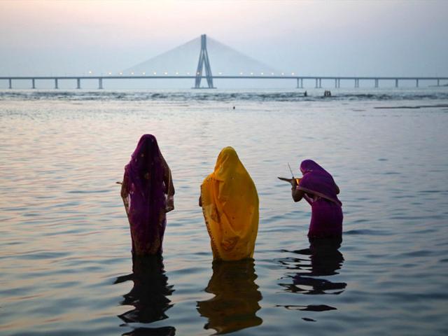 Hindu women offer prayers at sunset during Chhath Puja festival in Mumbai. (AP Photo)