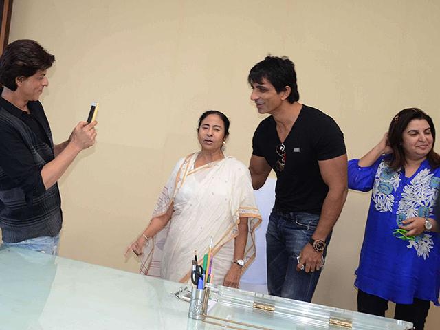 Shah Rukh Khan clicks pictures of filmmaker Farah Khan and actor Sonu Sood with West Bengal Chief Minister Mamata Banerjee. (Photo: IANS) 