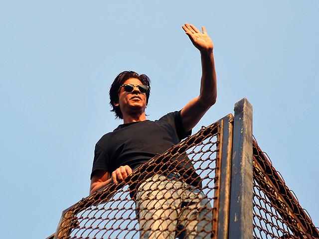 Shah Rukh Khan waves to fans during celebrations for his 49th birthday celebrations at his home in Mumbai on November 2, 2014. (AFP)
