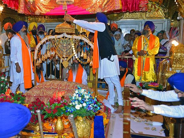 A priest sits behind the Sikh holy book during a 'Jalau', a splendour show of Sikhism's symbolic items, inside the Golden Temple in Amritsar. (AFP Photo)