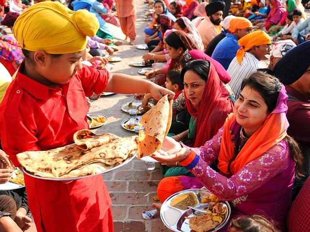 A small kid serves langar at Gurdwara Sri Guru Singh Sabha in Model Town in Jalandhar. (Pardeep Pandit/ HT Photo)