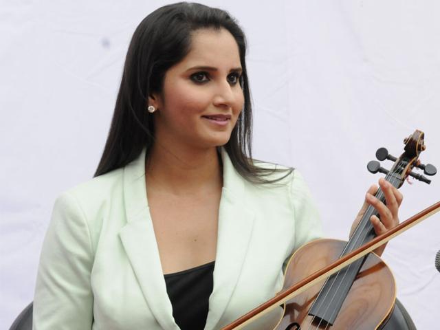 Sania Mirza tries her hand at violin which was played by one of the students of SDPS Women's College in Indore on Friday. (Amit K Jaiswal/HT photo)