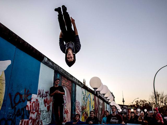 A man rehearses a part of 'Circus transcends borders' show at the East Side Gallery in Berlin, on the eve of the 25th anniversary of the fall of the Berlin Wall. (AFP Photo)