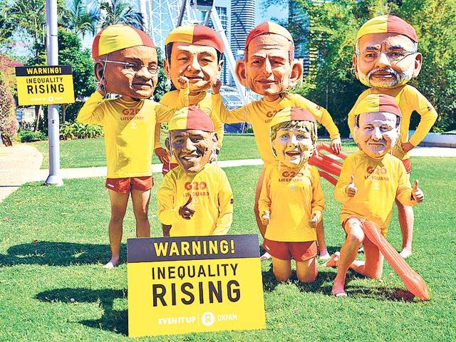 Protesters-wearing-fiberglass-heads-depicting-world-leaders-and-dressed-in-lifesaver-uniforms-to-highlight-the-need-to-halve-global-inequality-pose-on-the-banks-of-the-Brisbane-River-ahead-of-the-G20-Summit-in-Brisbane-AFP-PHOTO Protesters-wearing-fiberglass-heads-depicting-world-leaders-and-dressed-in-lifesaver-uniforms-to-highlight-the-need-to-halve-global-inequality-pose-on-the-banks-of-the-Brisbane-River-ahead-of-the-G20-Summit-in-Brisbane-AFP-PHOTO