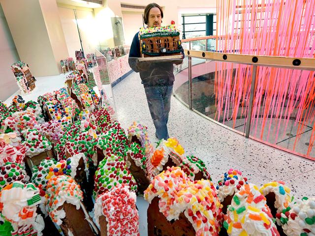 Chef Jon Lovitch carries the Cinnamon & Nutmeg Railroad station, one of his gingerbread house creations, for placement in his GingerBread Lane display, at the New York Hall of Science, in the Queens borough of New York. (AP photo)