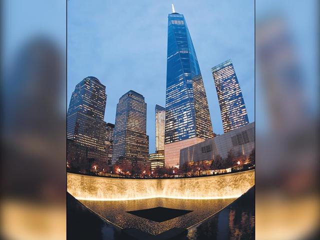 At 541 m, the One World Trade Center raises high above a reflecting pool in New York, USA. It is the fourth-tallest building in the world.
