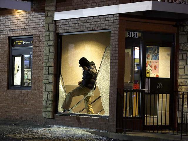 A man steps out of a vandalized store after the announcement of the grand jury decision in Ferguson. (AP Photo)
