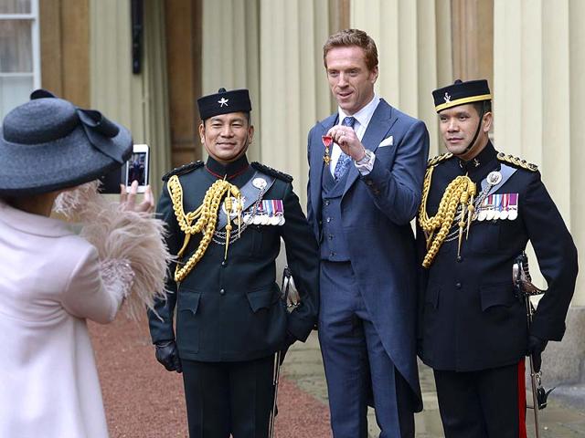 Actor Damian Lewis (C) holds his Officer of the Order of the British Empire (OBE) medal, standing with Gurkha soldiers, as he poses for a photograph shot by his wife Helen McCrory. (Reuters) Actor Damian Lewis (C) holds his Officer of the Order of the British Empire (OBE) medal, standing with Gurkha soldiers, as he poses for a photograph shot by his wife Helen McCrory. (Reuters)