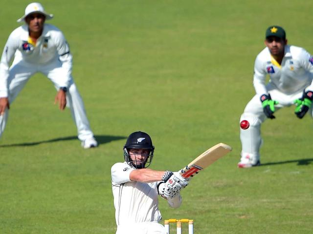 New Zealand batsman Kane Williamson (C) hits a shot as Pakistani wicketkeeper Sarfraz Ahmed (R) and teammte Younis Khan (L) look on during the third day of the third Test match at the Sharjah cricket stadium. (AFP Photo)