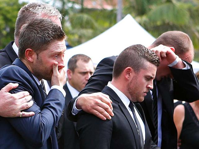 Australian cricket team captain Michael Clarke (L) is comforted as he cries with other mourners as the casket containing Australian cricketer Phillip Hughes is driven away after his funeral service in the town of Macksville, located north of Sydney. (Reuters) Australian cricket team captain Michael Clarke (L) is comforted as he cries with other mourners as the casket containing Australian cricketer Phillip Hughes is driven away after his funeral service in the town of Macksville, located north of Sydney. (Reuters)