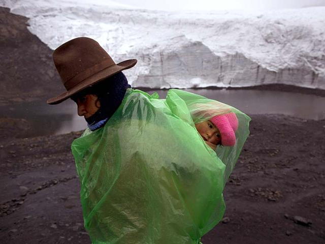 Fausta Ortiz, 38, Pastoruri's glacier guardian, stands guard while carrying her daughter Lisoyun, 2, in Huaraz, Peru. (AP Photo)