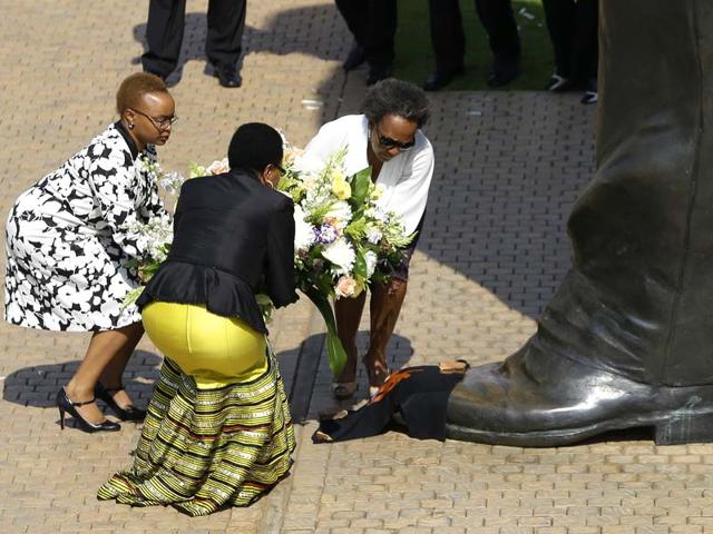 Nelson Mandela’s widow Graca Machel, second left, and unidentified family members place a wreath to the 9 meter tall bronze statue of the late former South Africa President Nelson Mandela outside Union Buildings in Pretoria, South Africa on the first anniversary of his death. (AP Photo)