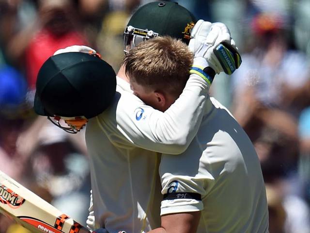 Australia's David Warner (R) hugs teammate Michael Clarke to celebrate his century on the first day of the first Test match between Australia and India at Adelaide Oval in Adelaide. (AFP Photo)