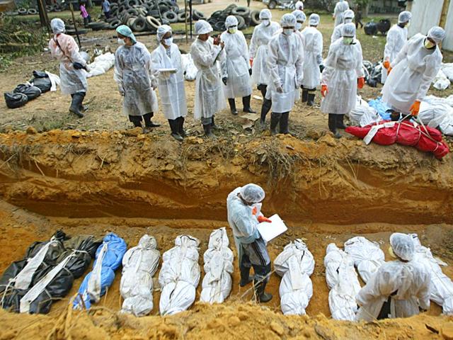 Thai health officials bury tsunami victims at a burial site in Takuapa, near Phuket, in January 2005. (Reuters)