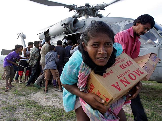Tsunami refugees receive supplies distributed by the USS Abraham Lincoln Carrier Strike Group in Krueng Raya, northeast of Banda Aceh, Indonesia in January 2005. (Reuters)