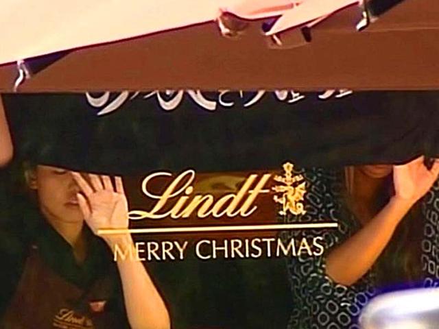 This screengrab taken from the Australian Channel Seven broadcast shows presumed hostages holding up a flag with Arabic writing inside. (AFP Photo)