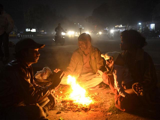 People lit a bonfire to beat the chill in Bhopal on Monday as the maximum temperature dipped to 20.4 degrees Celsius from 26 degrees. (Mujeeb Faruqui/HT photo)
