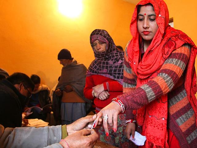 A polling officer marks the finger of a voter with indelible ink inside a polling station during the fifth phase of voting, at Satrayan village near the India-Pakistan international border near Jammu. (AP Photo)