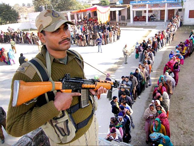 A security person keeps vigil at a polling station during the Jammu and Kashmir assembly elections. (PTI Photo)