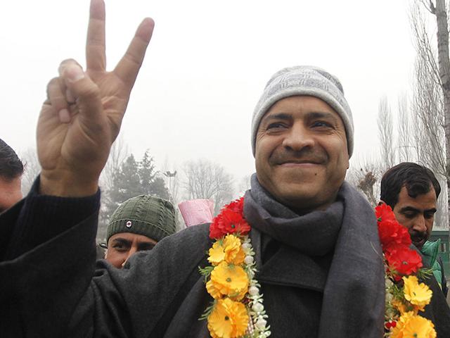 Mohammad Ashraf Mir of PDP flashes a victory sign to the media outside a counting center in Srinagar on Tuesday. (Waseem Andrabi/HT Photo)