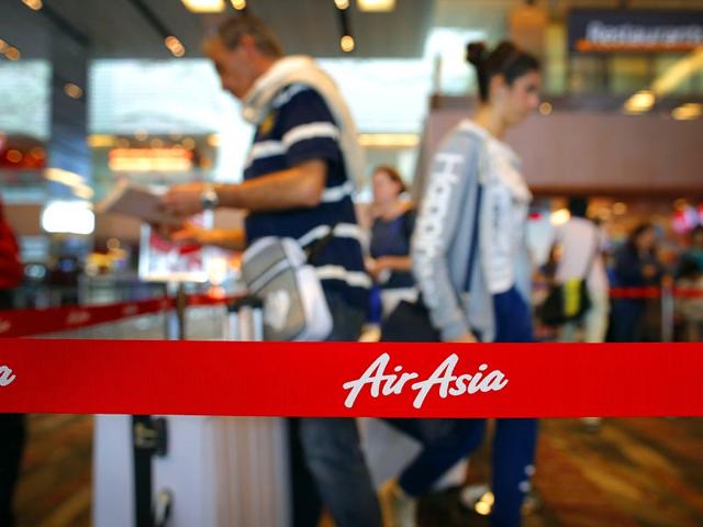 Passengers queue at AirAsia's check-in counters, at the Changi International Airport in Singapore. (AP Photo)