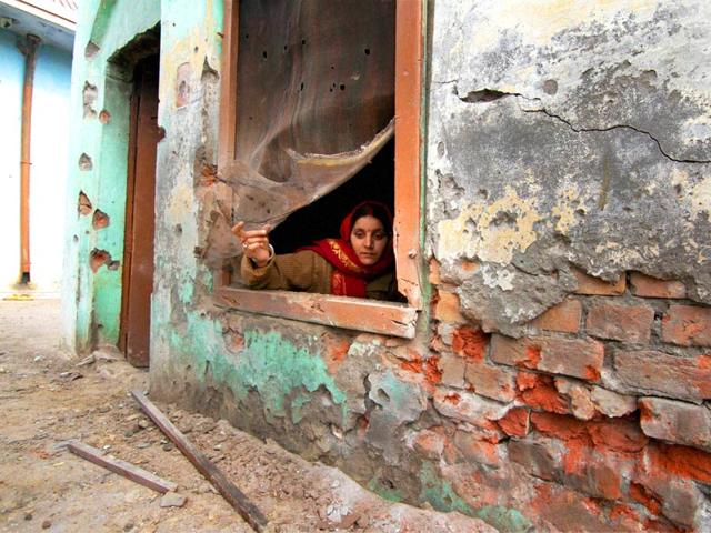 A woman sits by the window of a house damaged by shelling from the Pakistani side, at Bainglar village in Samba sector. (PTI Photo) A woman sits by the window of a house damaged by shelling from the Pakistani side, at Bainglar village in Samba sector. (PTI Photo)