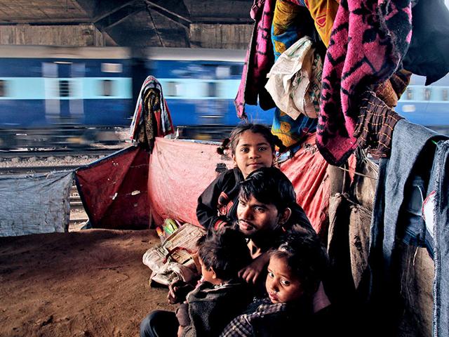 Adarsh Kumar, 22, a street vendor, plays with his three children in front of his shanty near Okhla station. “There is no New Year eve or Christmas celebration in our life. They are just like any other days. Our day begins with a struggle to arrange at least two meals. Winters makes it even more difficult. It is very tough to spend shivering nights under the open sky,” said Kumar. (Subrata Biswas/HT Photo)