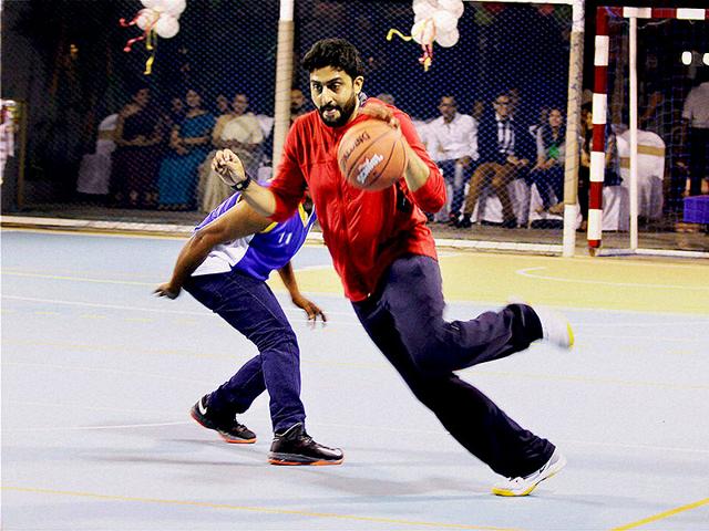 Bollywood actor Abhishek Bachchan plays basketball during the launch of a multi-sport court at Jamnabai Narsee School in Mumbai on Sunday. (PTI Photo)