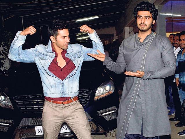 Varun Dhawan strikes a pose for the shutterbugs, while Arjun Kapoor is happy posing for Dhawan. (Photos: Yogen Shah)