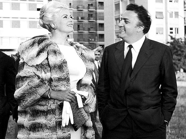 In this May 29, 1961 photo, Swedish actor Anita Ekberg and Italian movie director Federico Fellini stand talking in a Rome suburb. Anita Ekberg, the Swedish-born actor and sex-symbol of the 1950s and '60s who was immortalized bathing in the Trevi fountain in La Dolce Vita, has died. She was 83. Ekberg's lawyer Patrizia Ubaldi confirmed her death Sunday, January 11, 2015. (AP)