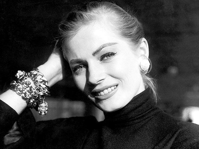 In this November 15, 1955 photo, Swedish actor Anita Ekberg poses for a photograph on her arrival at London airport from Stockholm to take part in the film Zarak Khan, with Victor Mature, Michael Wilding and Eunice Gayson. Anita Ekberg, the Swedish-born actor and sex-symbol of the 1950s and '60s who was immortalized bathing in the Trevi fountain in La Dolce Vita, has died. She was 83. Ekberg's lawyer Patrizia Ubaldi confirmed her death Sunday, January 11, 2015. (AP)