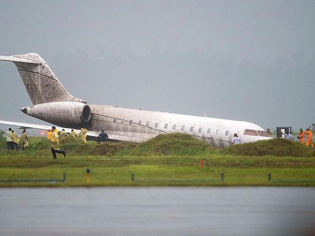 Bystanders and airport staff rush to offer help after a plane accident next to the tarmac of the international airport in Tacloban. (AFP Photo)