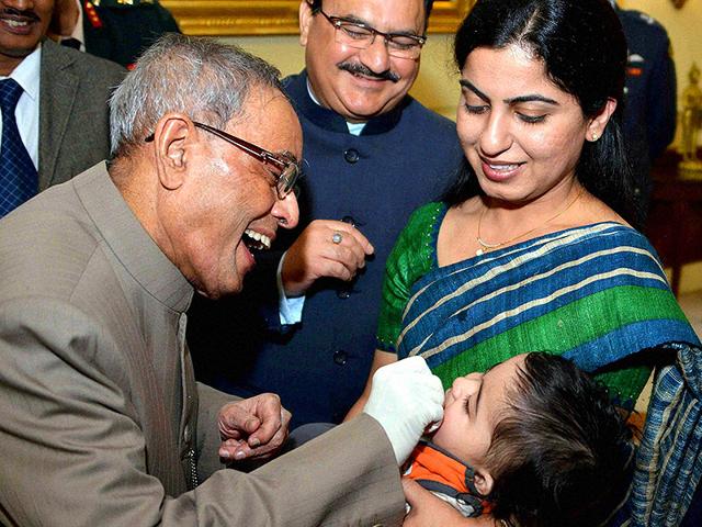 President Pranab Mukherjee administes polio drops to a child to launch the Pulse Polio programme at Rashtrapati Bhavan in New Delhi. (PTI Photo)