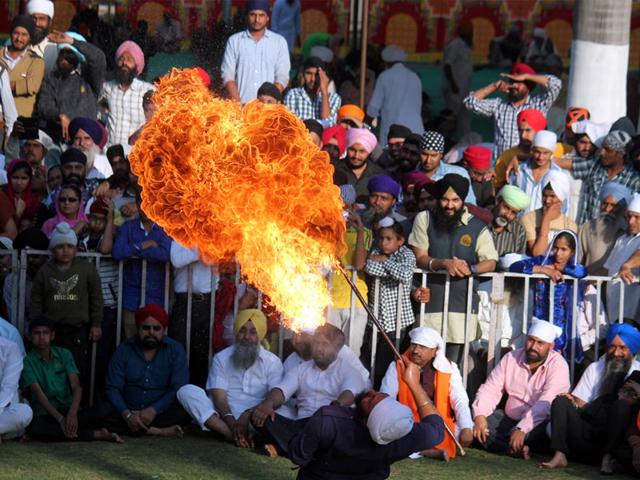 A young Sikh blows out fire from his mouth on the concluding day of a three-day religious meet in Indore on Sunday. (Shankar Mourya/HT photo)