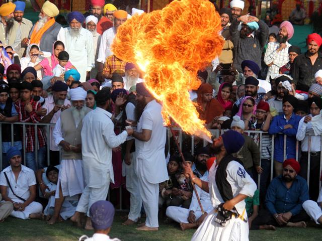 A young Sikh blows out fire from his mouth on the concluding day of a three-day religious meet in Indore on Sunday. (Shankar Mourya/HT photo)