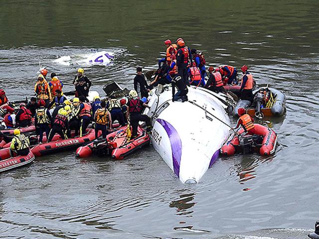 Rescuers remove a body by boat after a TransAsia Airways plane crash landed in a river in New Taipei City. (Reuters)