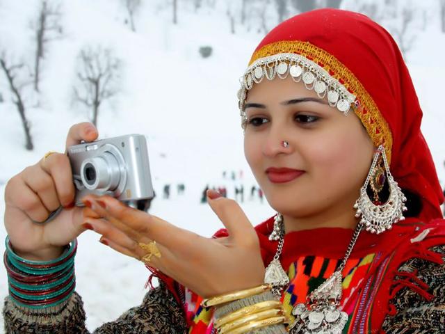 A tourist clicking scenic view of Manali town with her camera. Aqil khan/HT