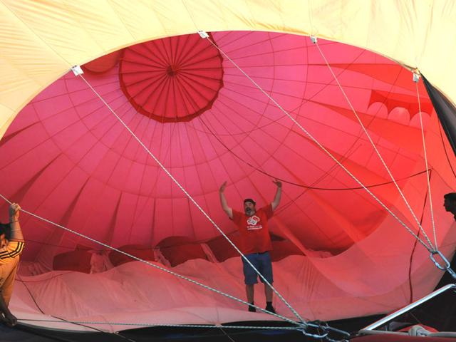 A man inflates a hot air balloon on the eve of 'Hot air balloon fest' organised as part of Bhoj adventure fest in Bhopal. (Mujeeb Faruqui/HT photo)