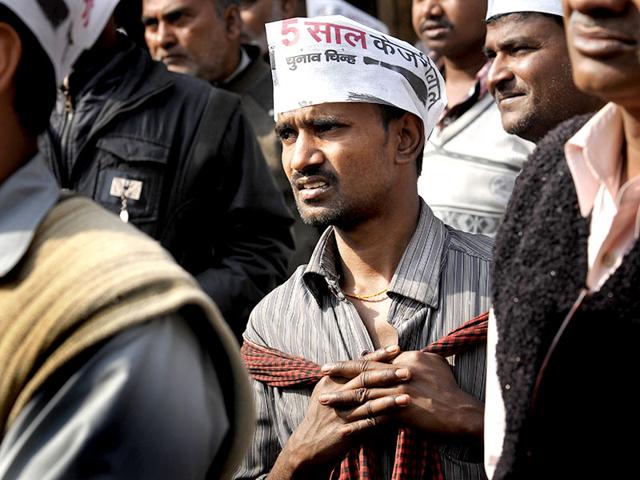 AAP supporters look at the screens installed near Ramlila Maidan for Kejriwal's swearing-in ceremony. (HT photo/Saumya Khandelwal)
