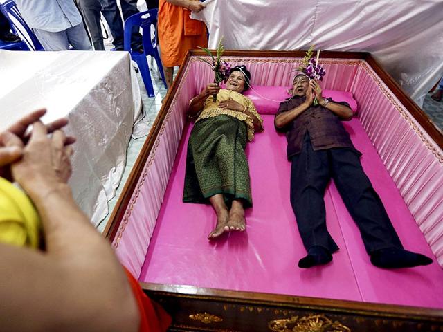 A groom and a bride lay inside a pink coffin during their wedding ceremony at Wat Takien temple in Nonthaburi province, on the outskirts of Bangkok on Valentine's Day. Ten Thai couples laid in the pink coffin during the wedding ceremony organised by the Buddhist temple on Valentine's Day. Couples believe laying briefly in the coffin will get rid of bad luck and usher happiness into their lives. (Reuters)